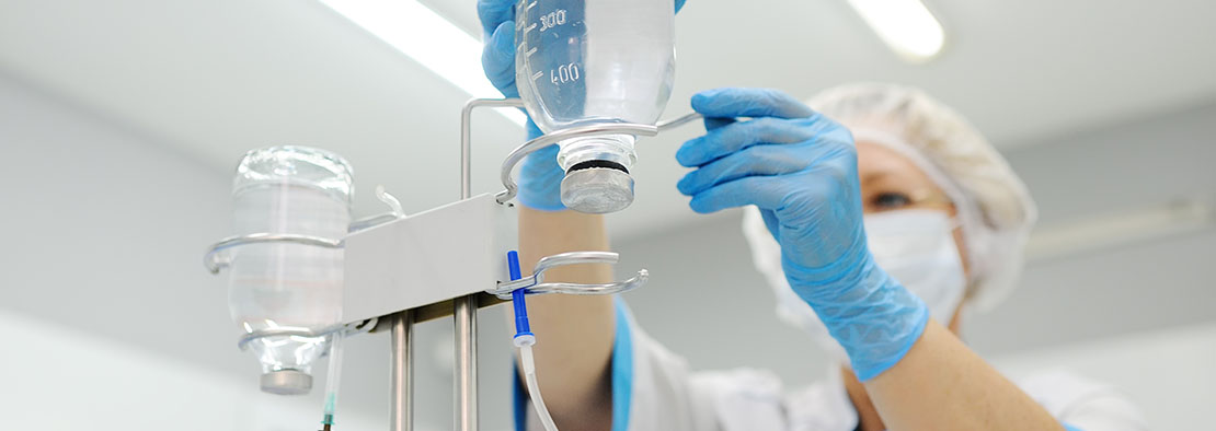 Врач подготавливает капельницу